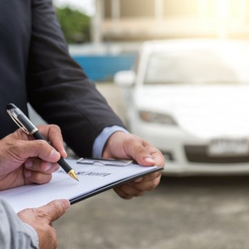 Extended Auto Warranty contract in front of car